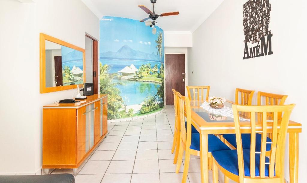 a dining room with a table and chairs and a painting at Pe na Areia Ótimo Apto Vista Mar in Praia Grande