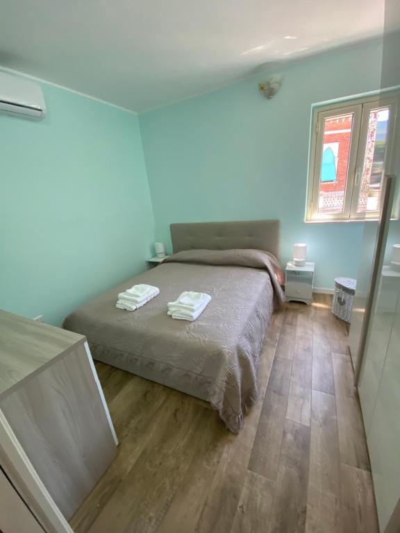 ein Schlafzimmer mit einem Bett mit zwei Handtüchern darauf in der Unterkunft Blue Jolie in Scilla
