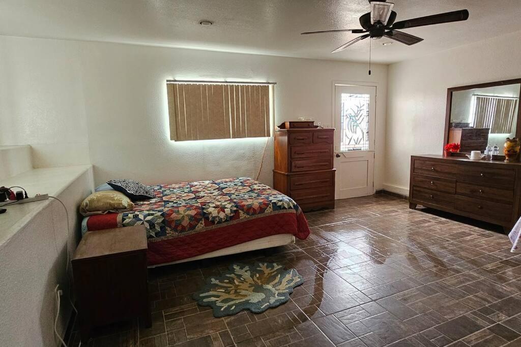 a bedroom with a bed and a dresser and a fan at Un lugar céntrico para descansar in Rosarito