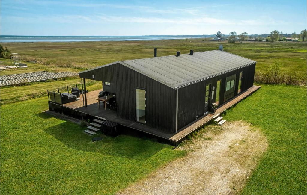una casa nera seduta in cima a un rigoglioso campo verde di Amazing Home In rsted With House Sea View a Kare