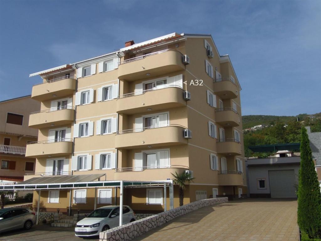 um edifício alto com carros estacionados em frente em Apartment in Dramalj with sea view, balcony, air conditioning, WiFi 4623-6 em Dramalj