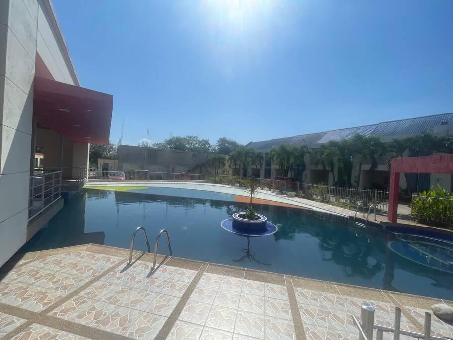 a large swimming pool with a table in front of a building at Casa Acacías - Meta in Acacías