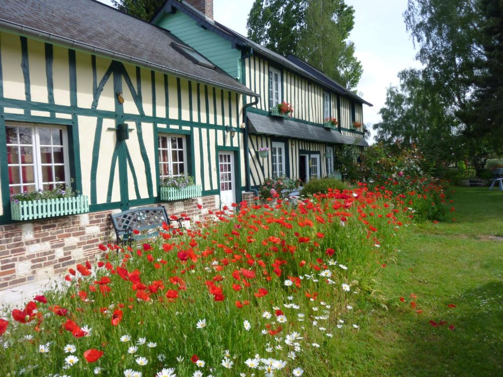 un jardin de fleurs devant une maison dans l'établissement Chambre d'hôtes Au Fil De L'eau, à Jumièges