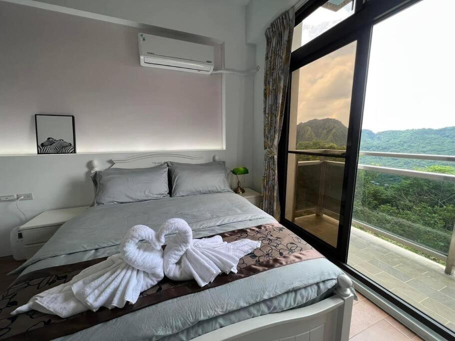 um quarto com uma cama com toalhas em 林莊園包棟別墅Skydoorzi Villa em Guoxing