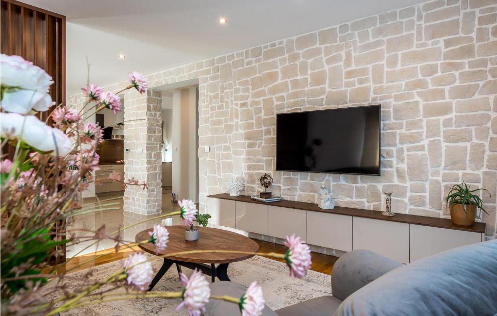 a living room with a brick wall with a tv at Stunning Home In Siveric With 5 Bedrooms, Jacuzzi And Outdoor Swimming Pool in Siverić