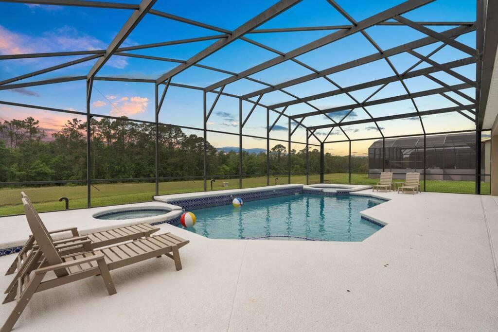 une piscine avec une chaise et un banc dans un bâtiment dans l'établissement Lakeview w/8 Bedroom 5 KingSuite 3 miles to Disney, à Kissimmee