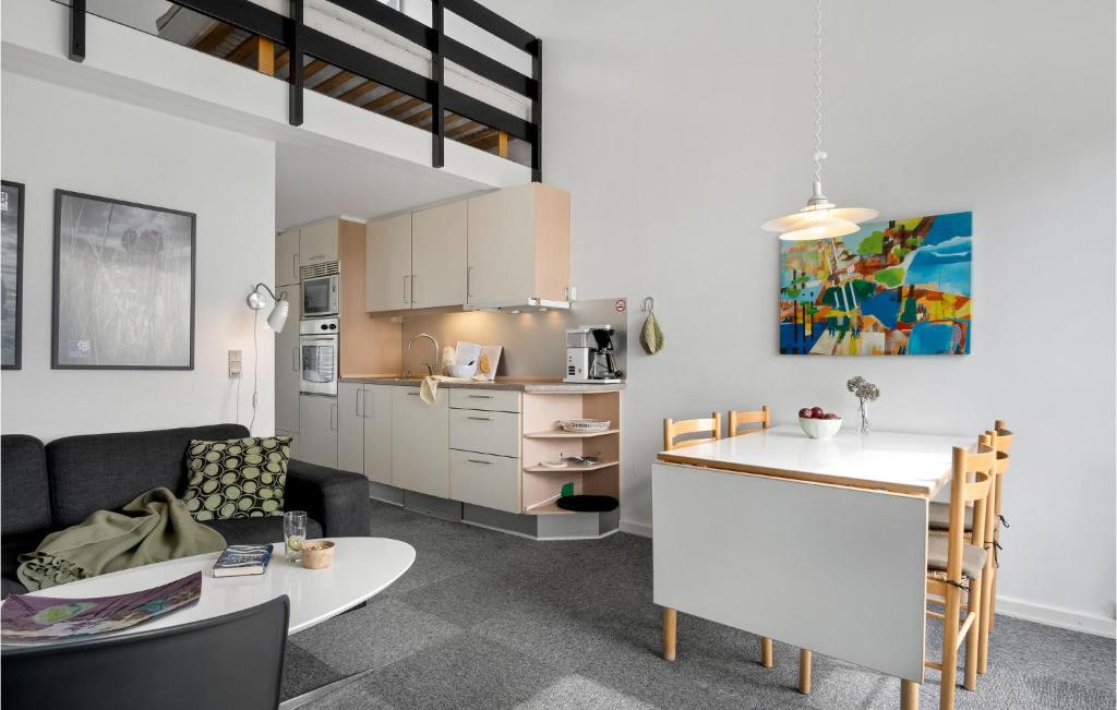 a kitchen and a living room with a couch and a table at Fanø Bad, Lejl 65 in Fanø