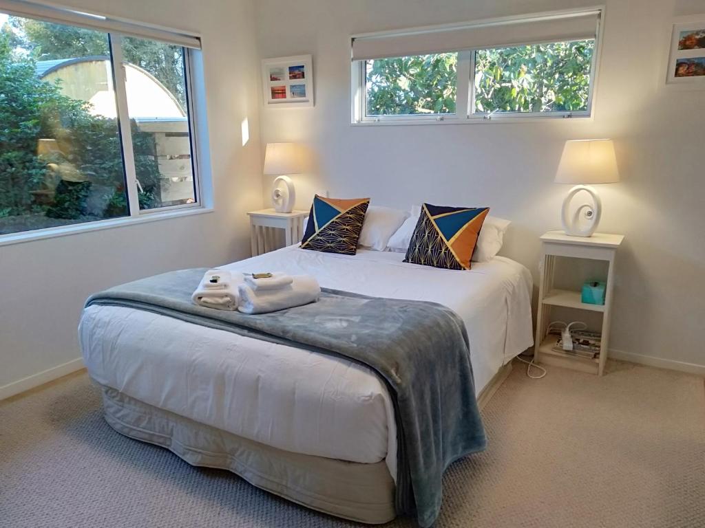 a bedroom with a large bed with two windows at Hidden Gem in Greytown