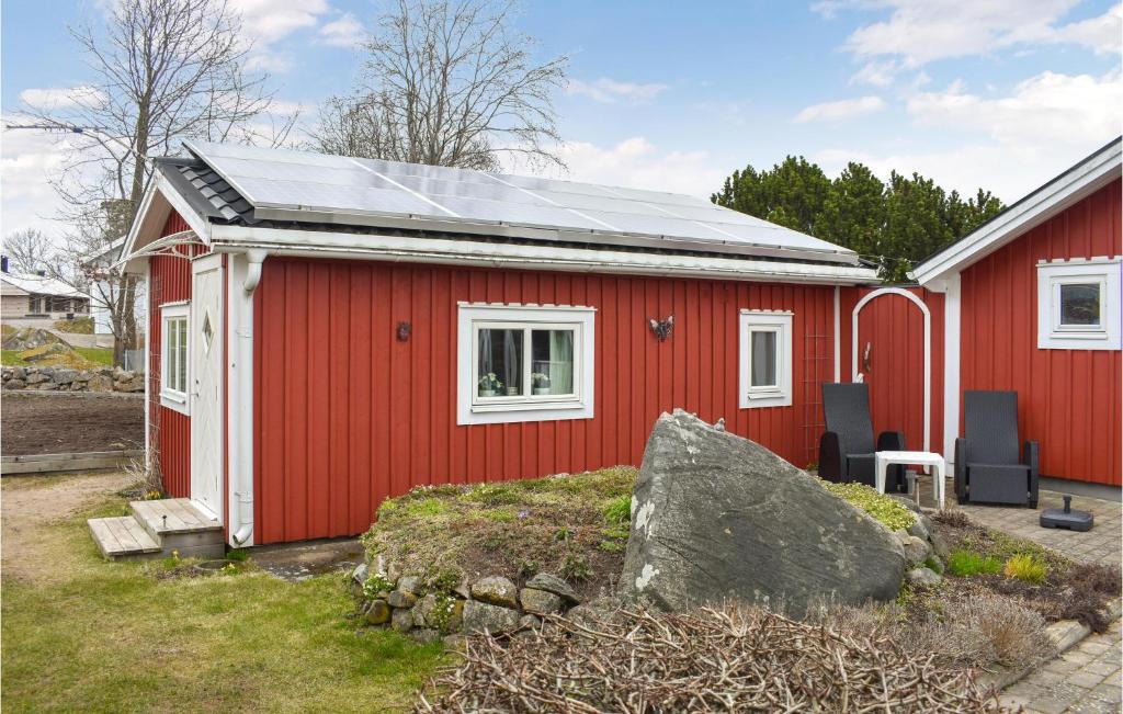una casa roja con techo solar en Beautiful Home In Ronneby With House Sea View, en Ronneby