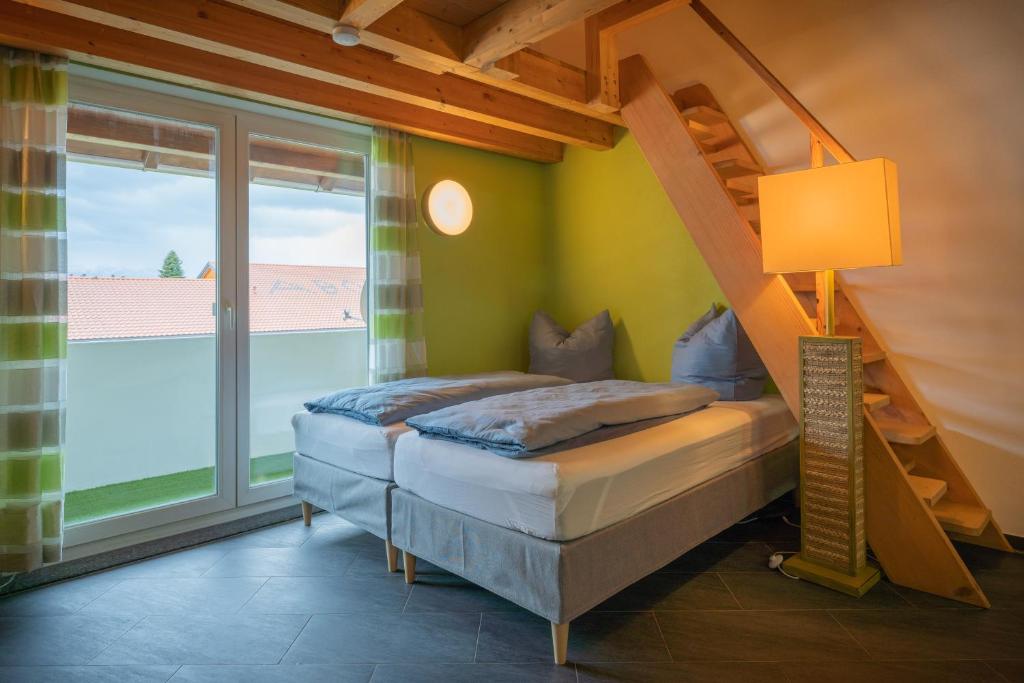 1 dormitorio con 2 camas y ventana en feworld living - near Salzburg city, en Freilassing