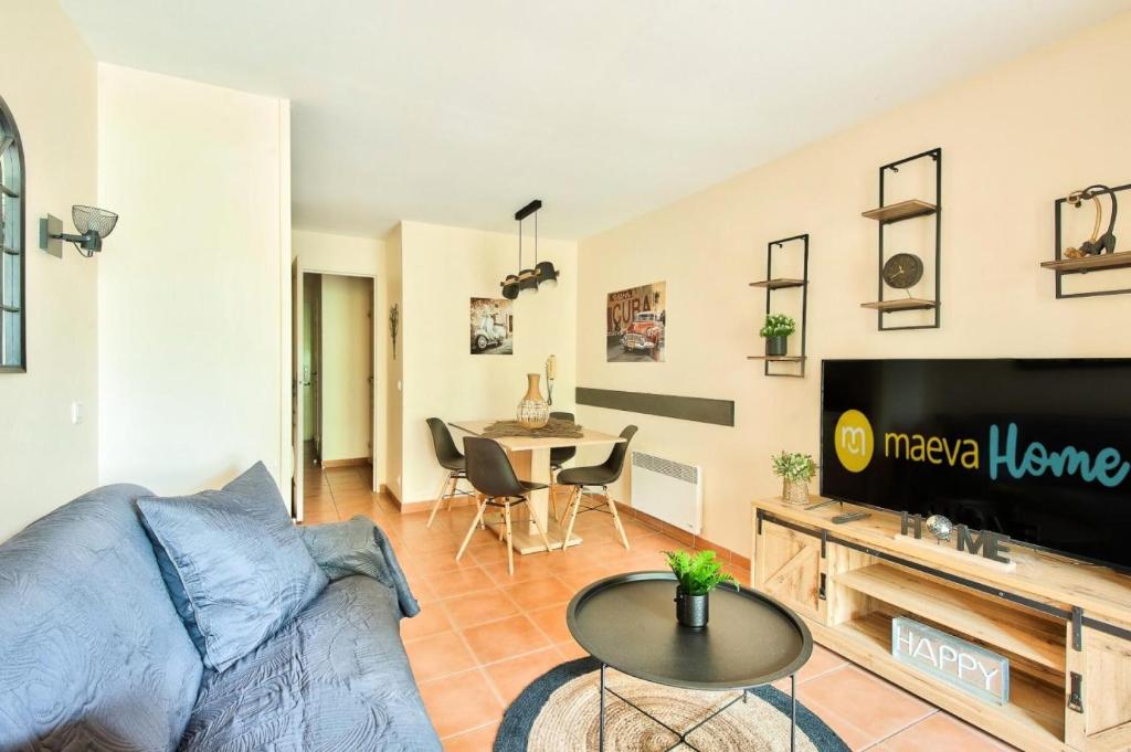 un salon avec un canapé, une télévision et une table dans l'établissement Village Pont Royal en Provence - maeva Home - Appartement 2 pièces 4 personnes - Sélection MAE-2964, à Mallemort