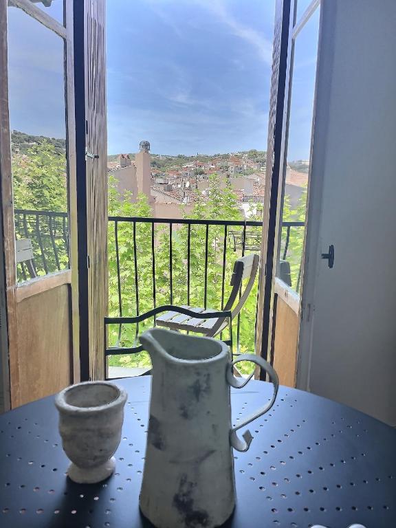 un vase posé sur une table devant un balcon dans l'établissement CALADO by K6 Conciergerie, à Cassis
