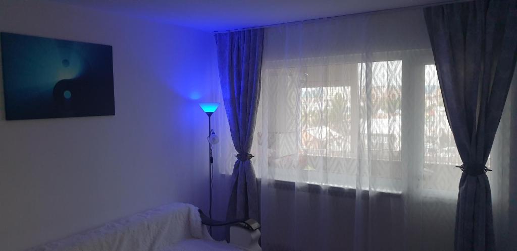 a room with a bed and a window with a lamp at Hellen Apartament in Târgovişte