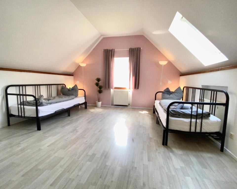 um quarto no sótão com 2 camas e uma janela em Ferienwohnung auf Pferdehof em Dreetz