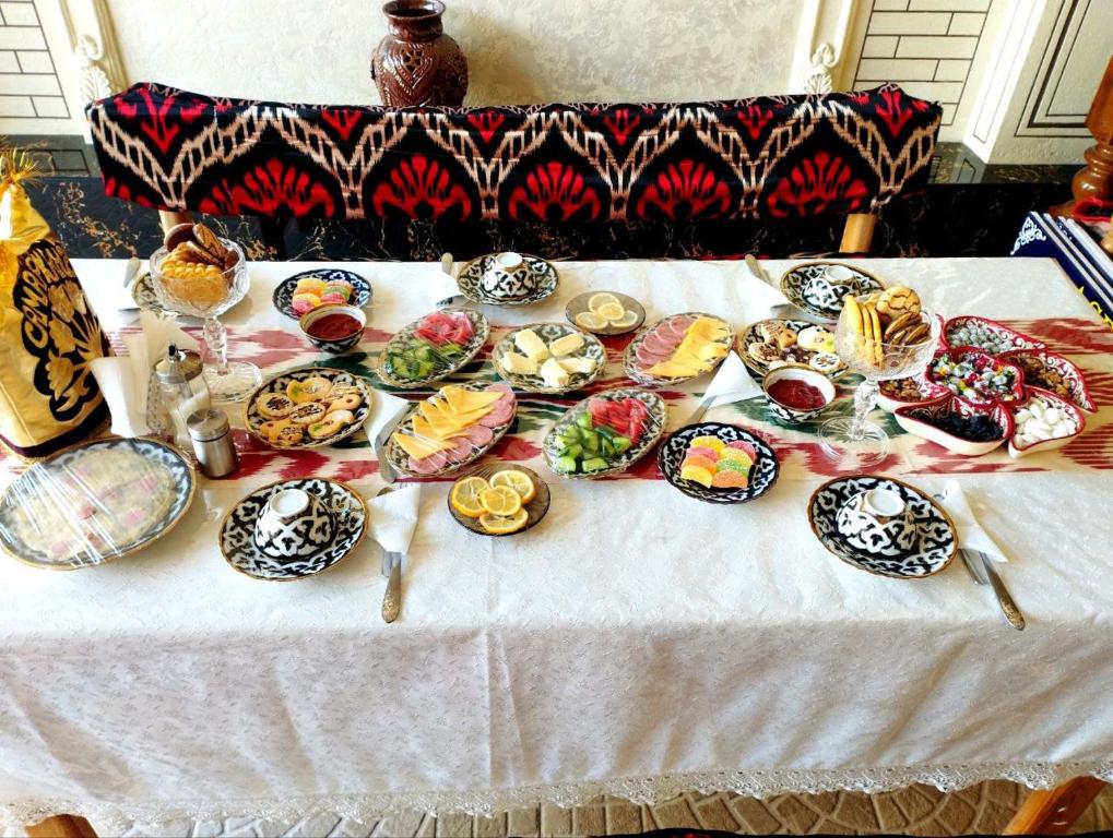 une table avec de nombreuses assiettes de nourriture dans l'établissement ASR GUEST HOUSE, à Samarcande