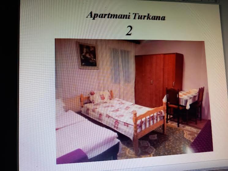 a picture of a bedroom with two beds and a table at Apartman Turkana 2 in Sarajevo