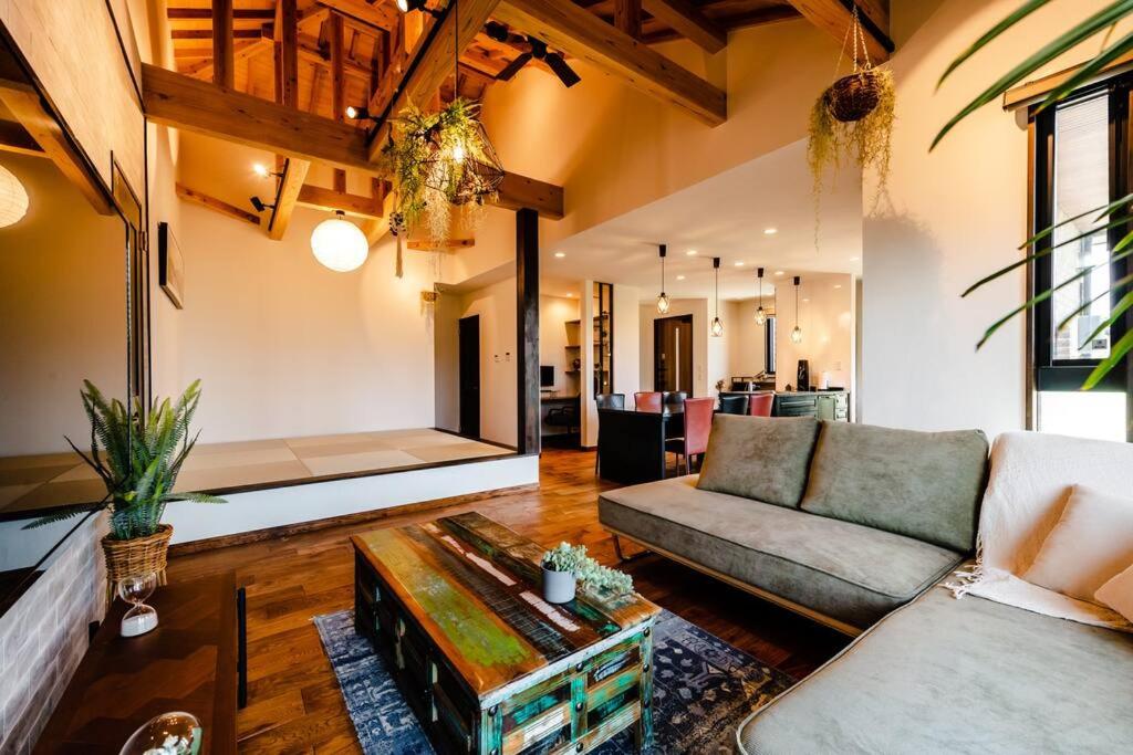 ein Wohnzimmer mit einem Sofa und einem Tisch in der Unterkunft The Villa Miyako in Hirara