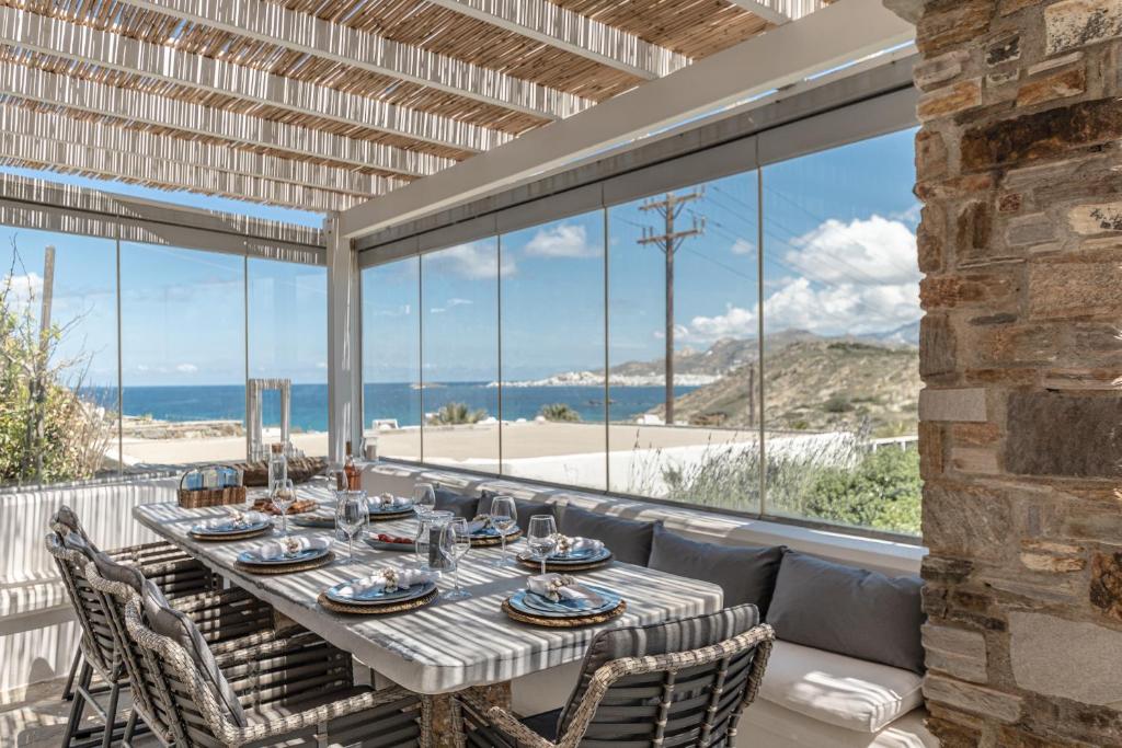 a dining room with a table and chairs and a large window at Casa Solmar, Stelida Naxos, by NaxosVibe in Stelida