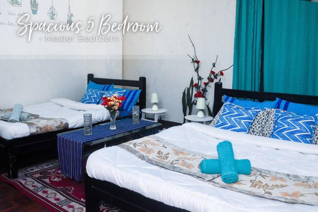 duas camas num quarto com azul e branco em 5 Bedrooms 4 Bath/toilet & Mountain View Fast Net em Baguio
