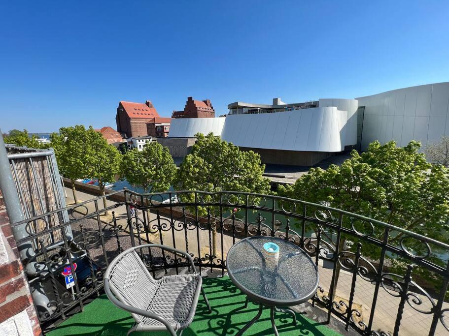 eine Terrasse mit 2 Stühlen und einem Tisch auf dem Balkon in der Unterkunft Traumwohnung am Altstadt Hafen Stralsund in Stralsund