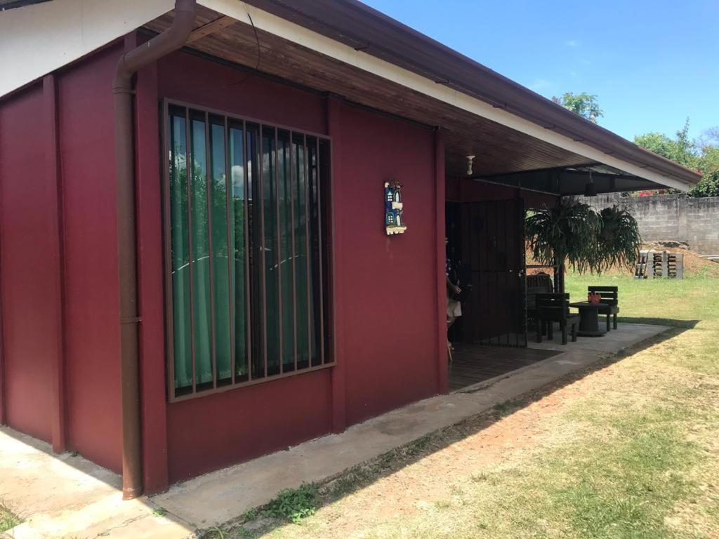 a red building with a window and a table at Casa en Atenas, entorno tranquilo in Atenas