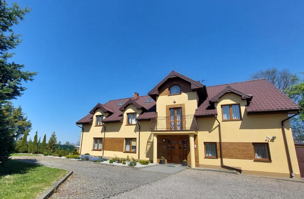 una gran casa amarilla con techo marrón en Na Wzgórzu, en Połchowo