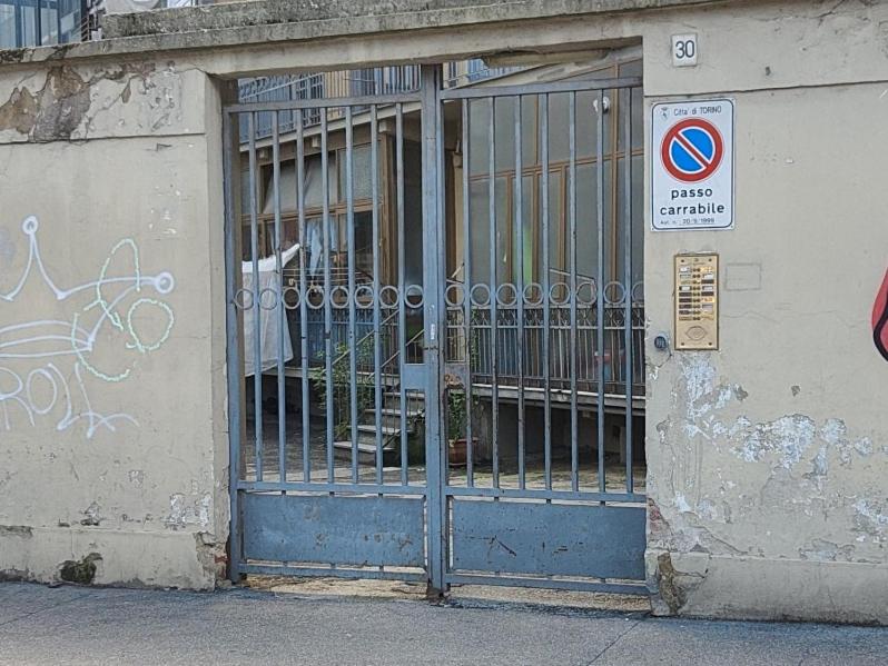 a gate on the side of a building with graffiti at Appartamento New: Lingotto in Turin