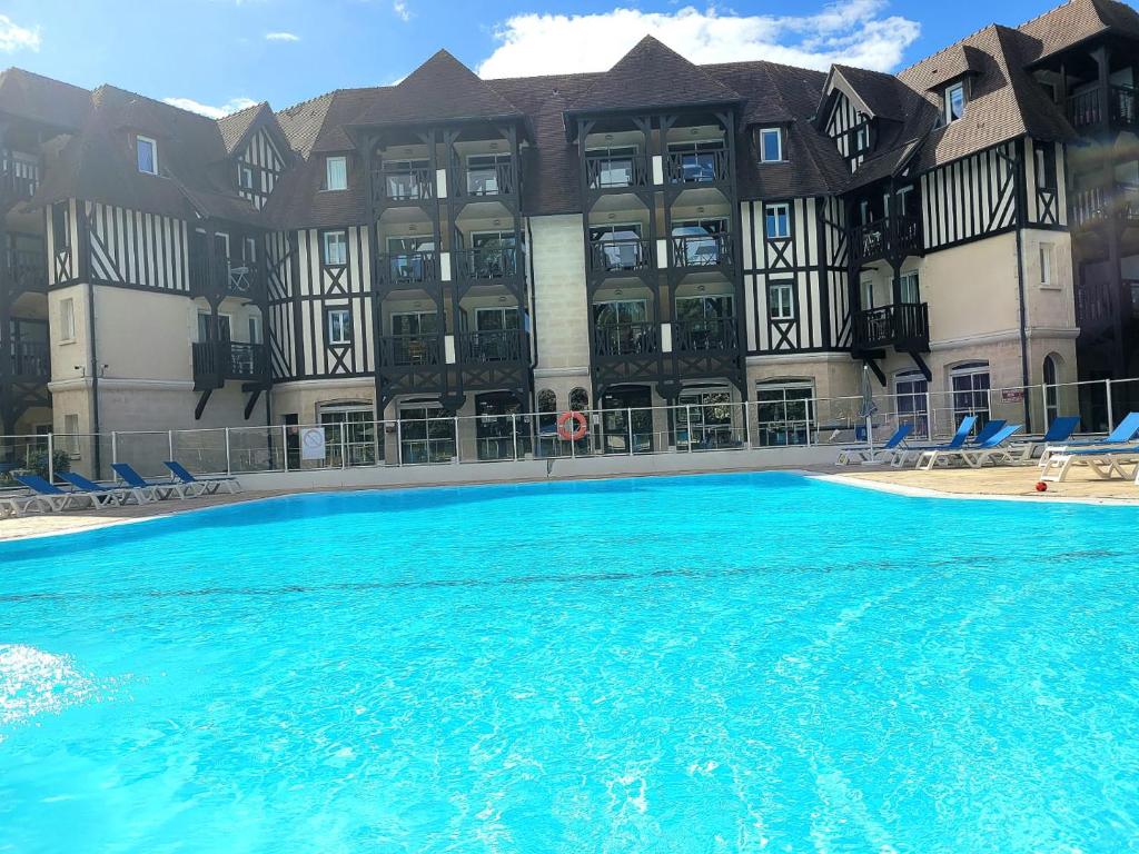 a large swimming pool in front of a building at Magnifique appartement 2 pièces in Deauville