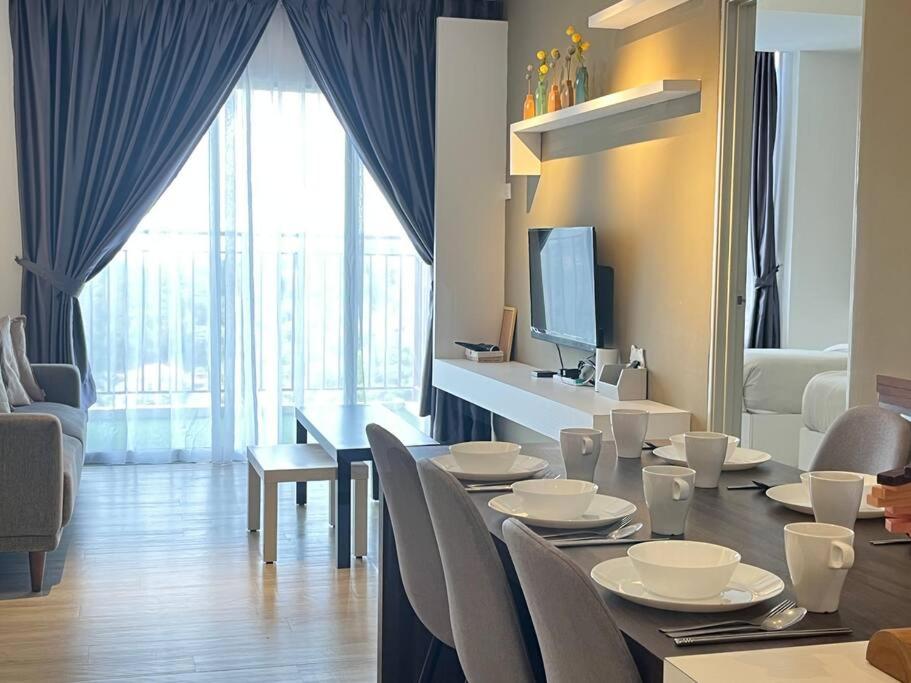 a dining room with a table and chairs and a television at Emerald Avenue Cozy 3R3B Apartment 715 in Brinchang
