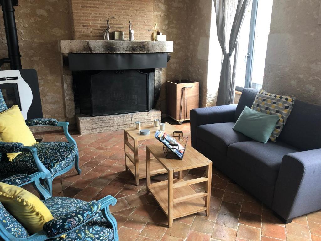 ein Wohnzimmer mit 2 Sofas und einem Kamin in der Unterkunft La Maison in La Chapelle-Saint-Martin-en-Plaine