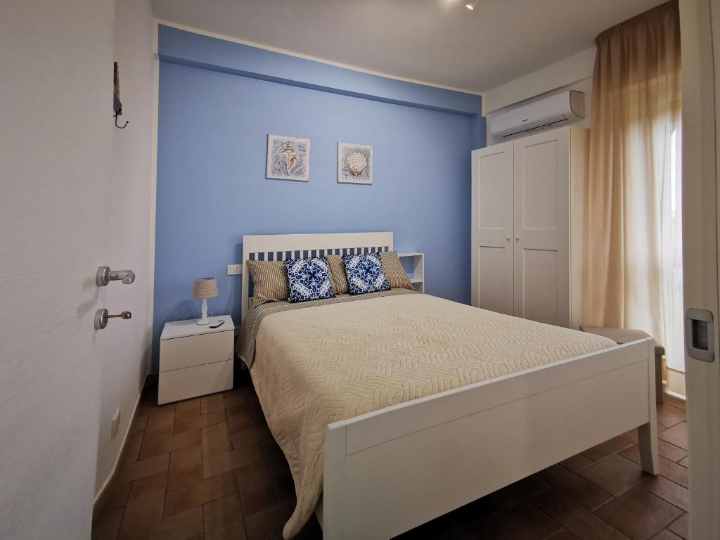 una camera con un letto con una parete blu di la finestra sul mare a marzamemi a Marzamemi