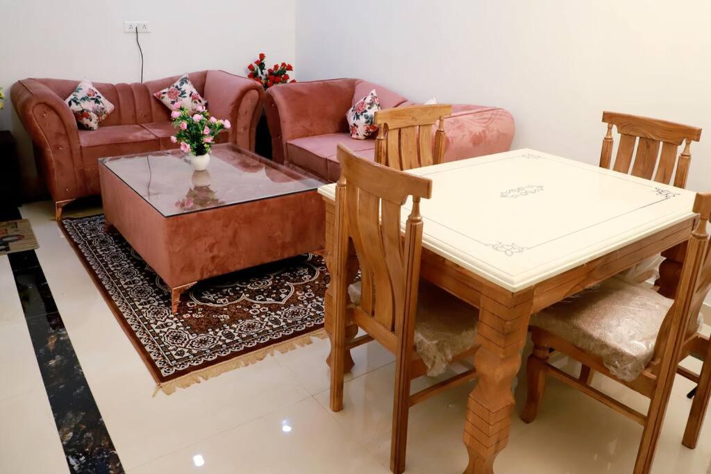 een woonkamer met een tafel en een bank bij Divine India Service Apartment 3Bhk, 2B Saket in New Delhi