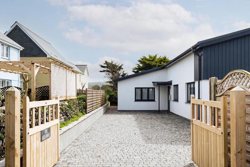 a house with a wooden gate and a driveway at The Hideaway, Modern 3 bed in Tintagel, Cornwall in Tintagel