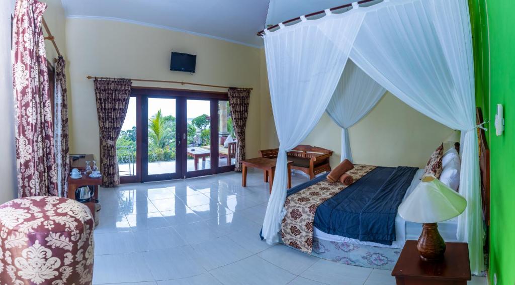 a bedroom with a bed with a canopy at Bali Bhuana Villas in Amed