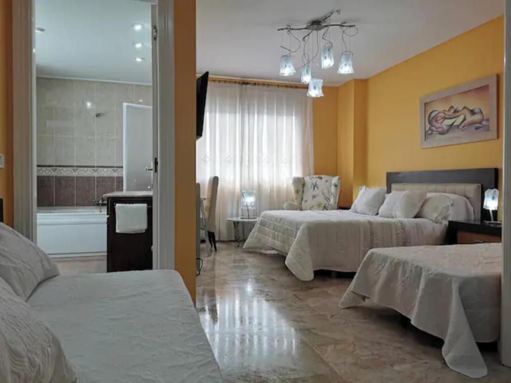 a hotel room with two beds and a bathroom at Apartamento en playa arenal de Burriana in Burriana