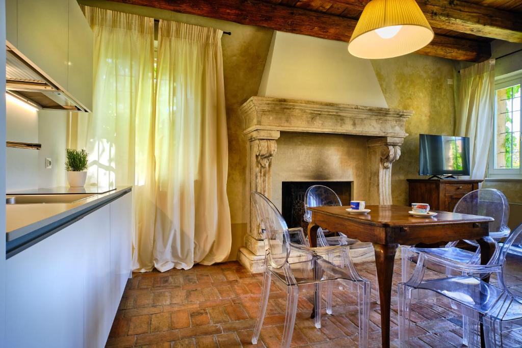a dining room with a table and chairs and a fireplace at Relais Corte Guastalla Apartments in Sona