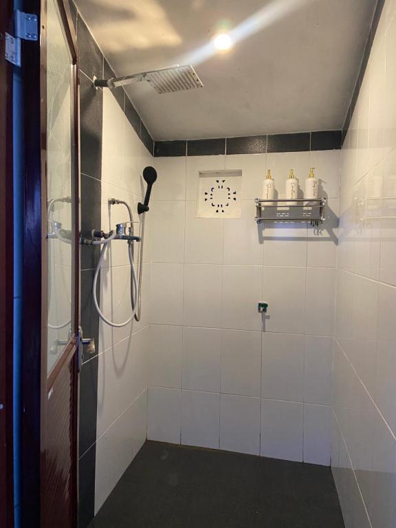 uma casa de banho com um chuveiro e um relógio na parede em Wanahita Camp em Gretek