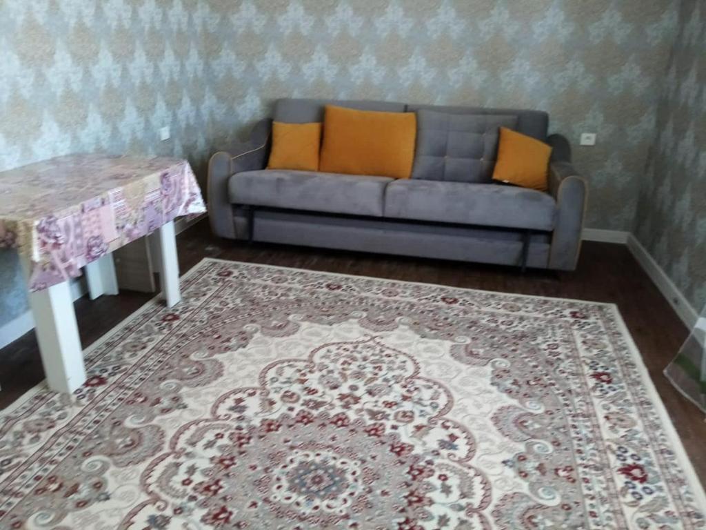 a living room with a couch and a table at Гостевой Дом in Qyzylorda