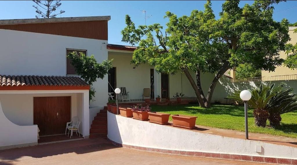 een huis met een patio en een tuin bij Villa Rita in Fontane Bianche