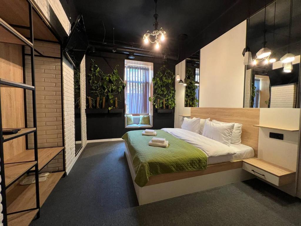リヴィウにあるBlum Hotelの植物のある部屋のベッド1台が備わるベッドルーム1室を利用します。
