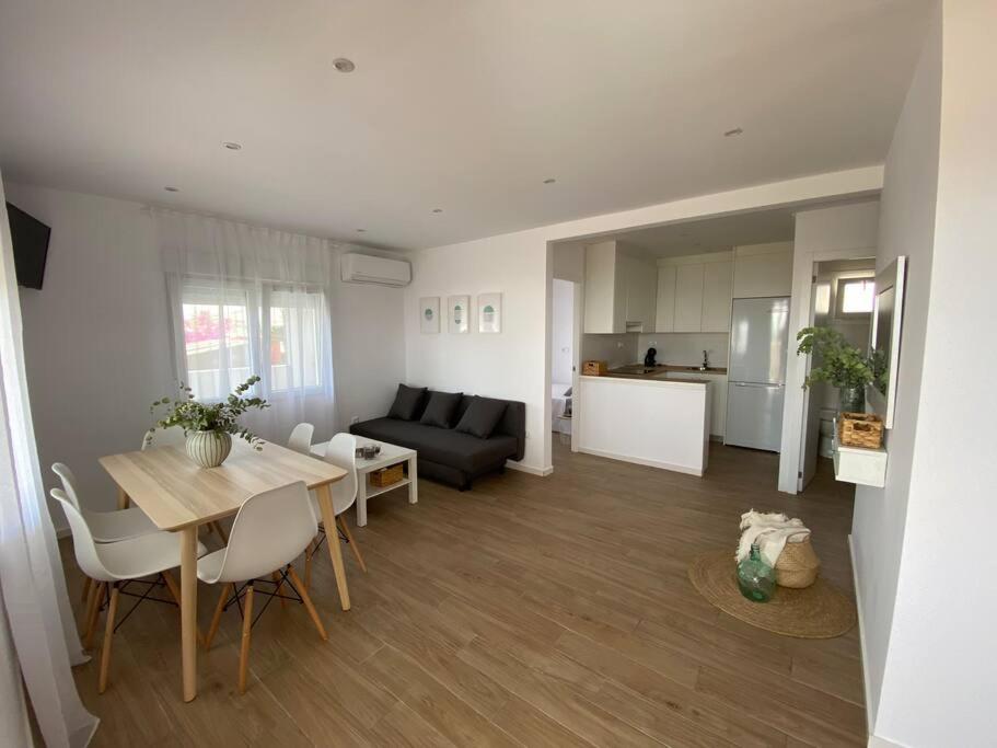 a kitchen and a living room with a table and a couch at Apartamento Paradis con encanto y vistas al mar in Vinaròs