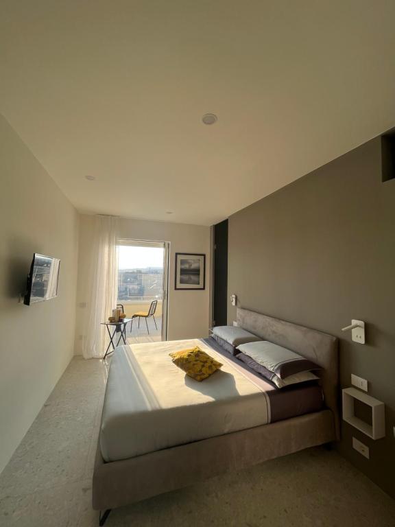 a bedroom with a large bed and a window at LA TERRAZZA SUL PORTO in Syracuse