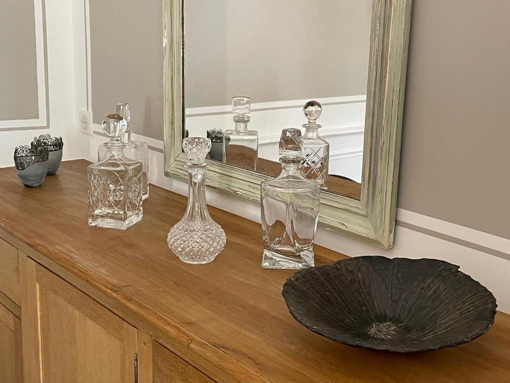 a group of glass bottles on a dresser in front of a mirror at La Pavoyère in Mormoiron