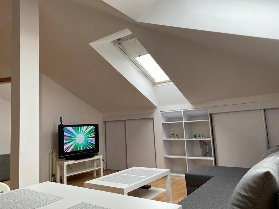 ein Wohnzimmer mit einem Flachbild-TV an der Decke in der Unterkunft Apartament NOWY in Ostrowo