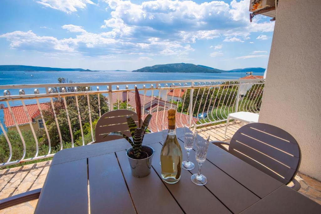 einen Tisch mit einer Flasche Wein und Gläsern auf dem Balkon in der Unterkunft Apartment Marina in Okrug Donji