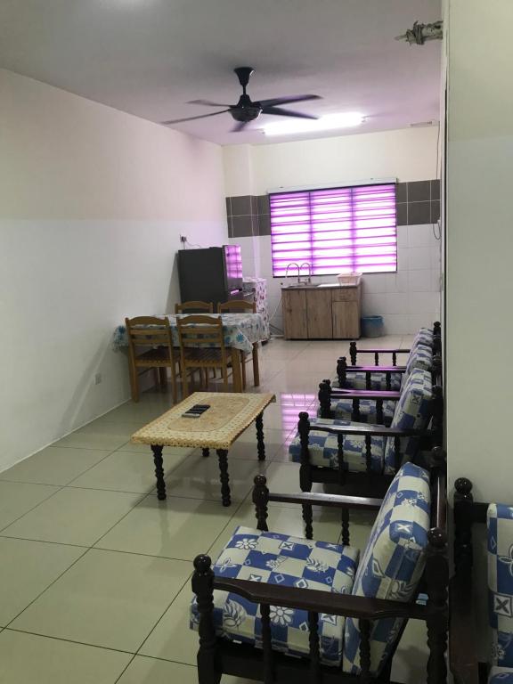 a room with chairs and tables and a ceiling fan at AZ HomeStay Bandar Puncak Alam in Bandar Puncak Alam