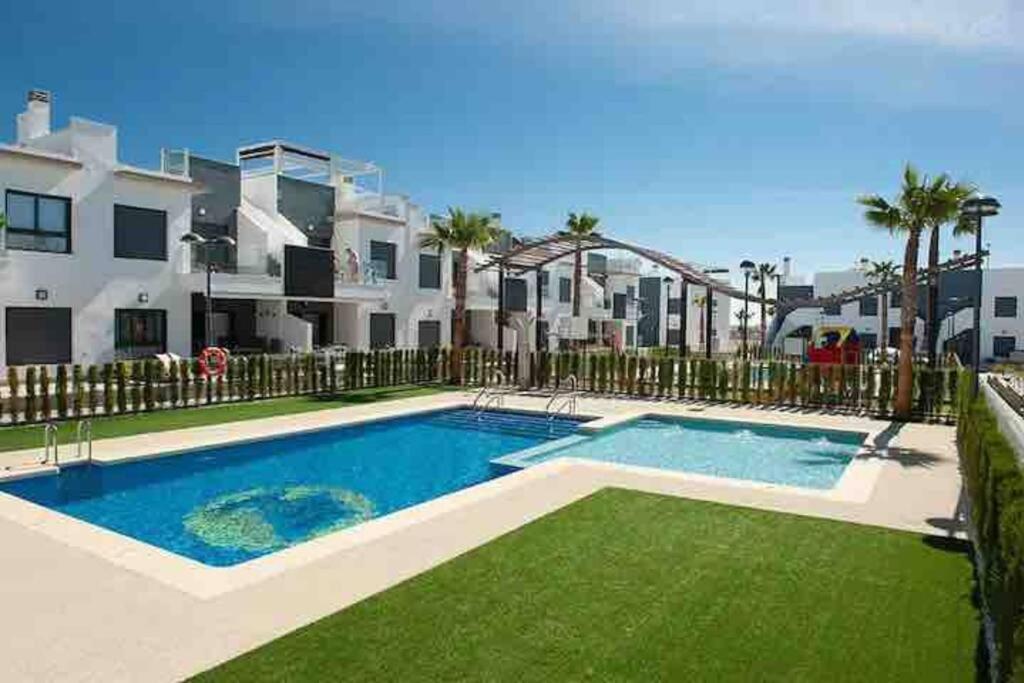 una piscina frente a un complejo de apartamentos en Beautiful Modern 2 bedroom, 2 bathroom apartment, en Pilar de la Horadada