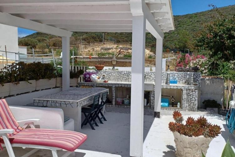 a patio with a table and chairs under a white pergola at Magi - Violetta in Ponza