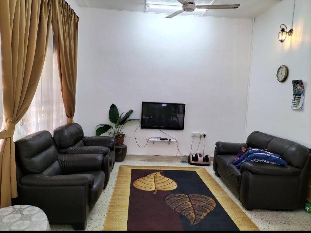 ein Wohnzimmer mit 2 Sofas und einem Flachbild-TV in der Unterkunft Che Na Homestay Pontian in Pontian Kecil