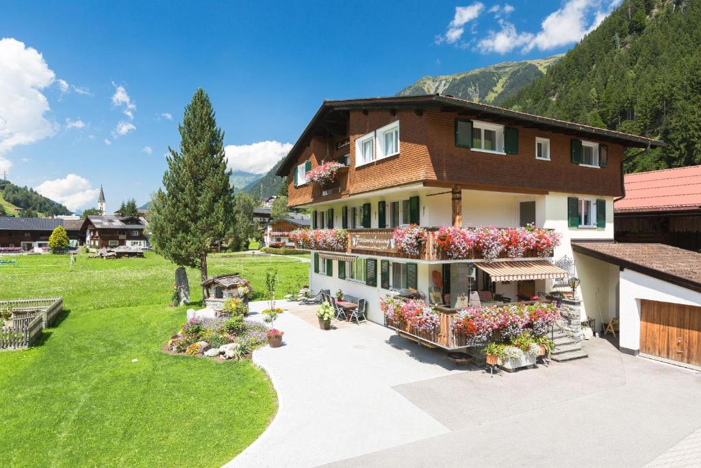 Una casa grande con flores al costado. en Landhaus Angelika, en Gaschurn